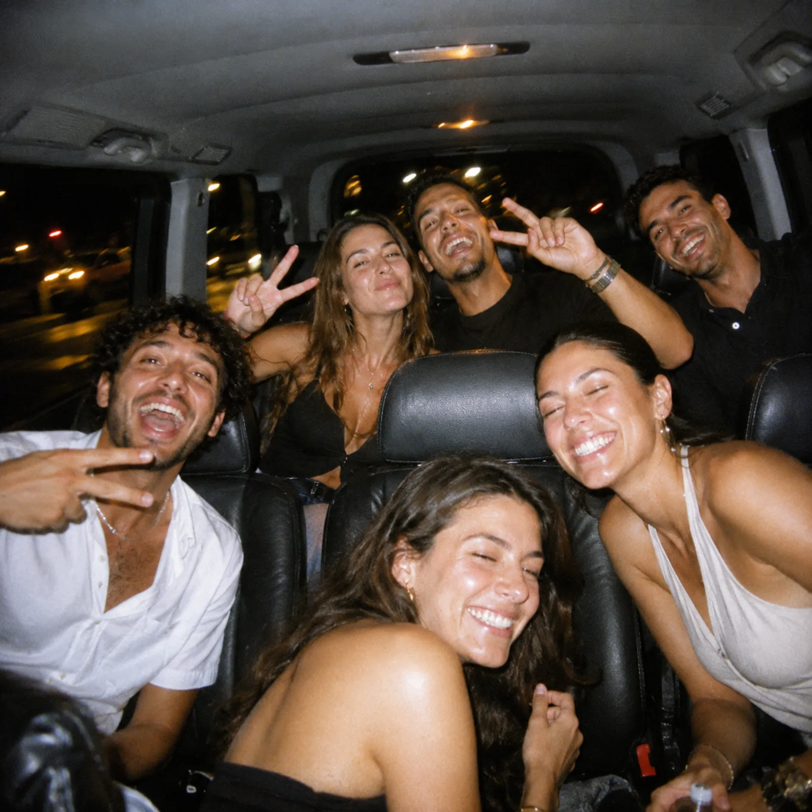 Six amis hilares entassés à l'arrière du van la nuit, photo flash argentique