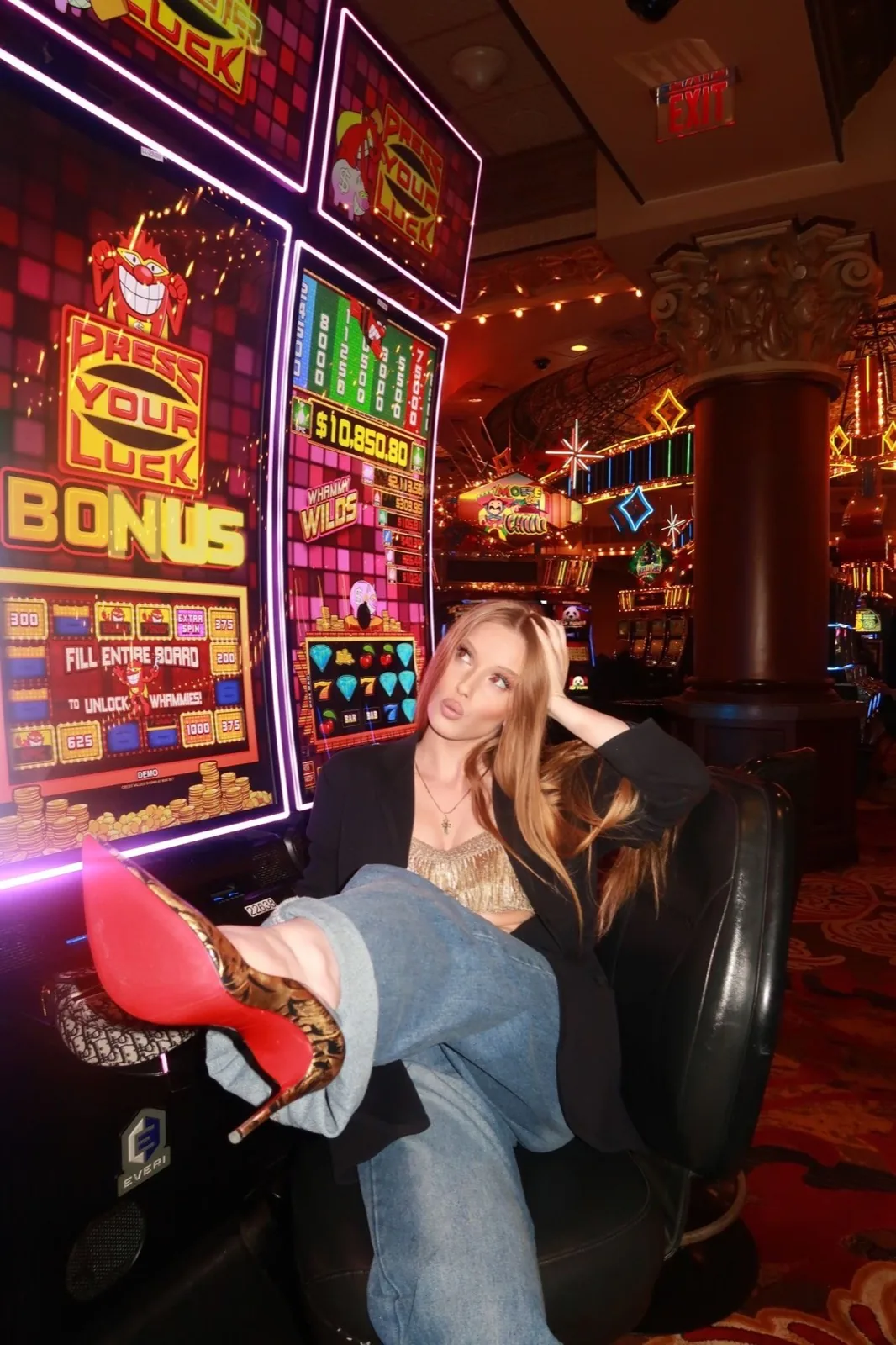 Jeune femme installée dans un fauteuil de casino sous les néons roses des machines à sous, photo argentique