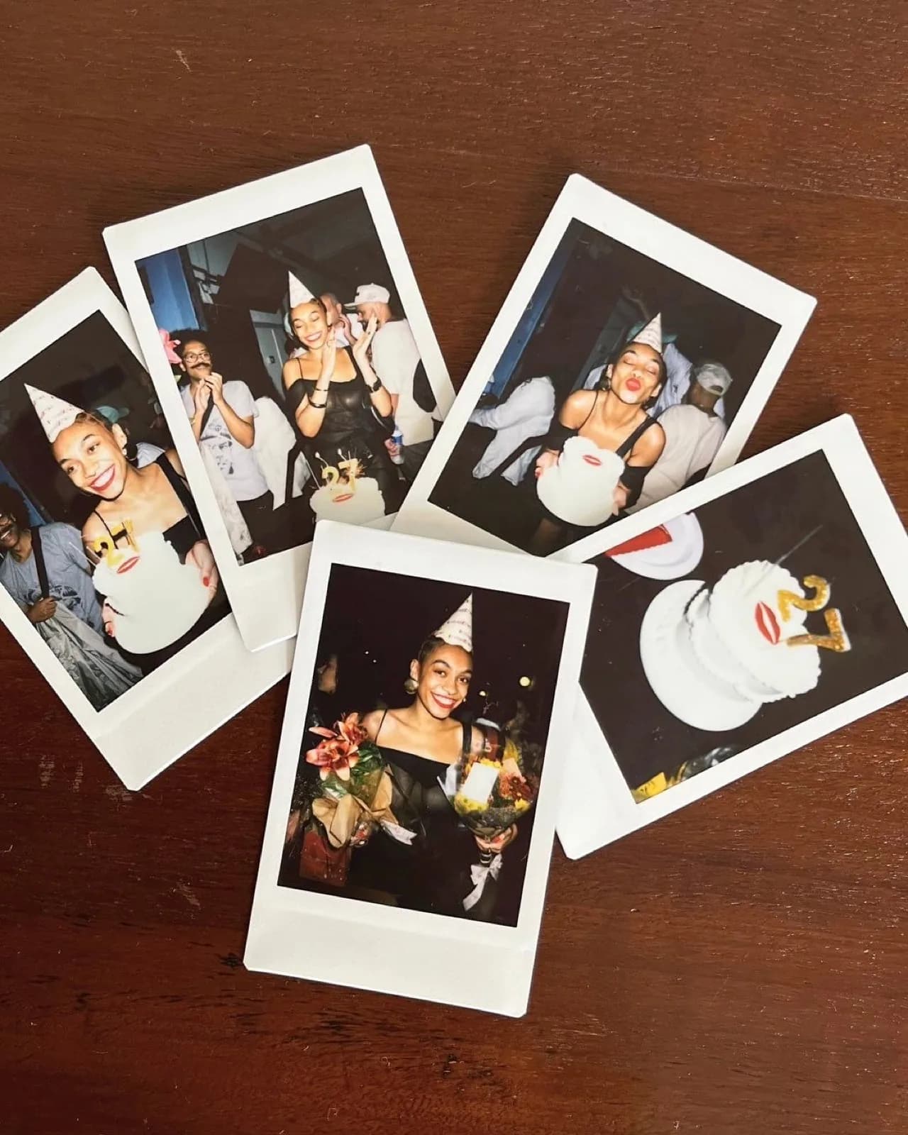 Cinq polaroids d'anniversaire éparpillés sur une table en bois